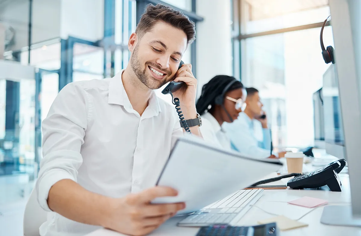 Office staff using business desk phones while working at computers